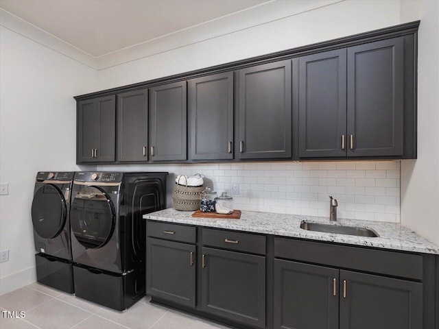 laundry area with sink, light tile patterned floors, cabinets, ornamental molding, and washing machine and clothes dryer