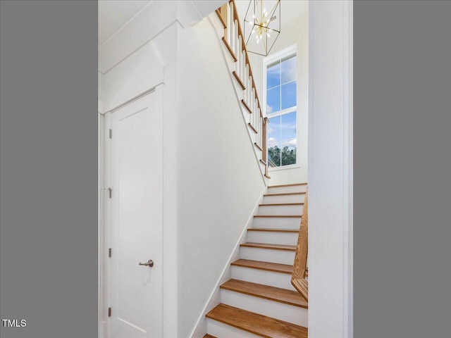 staircase with a chandelier