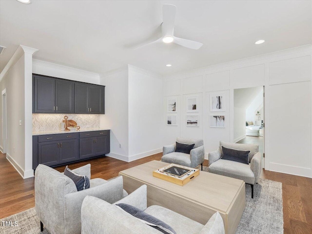 living room with dark wood-type flooring, ceiling fan, and crown molding