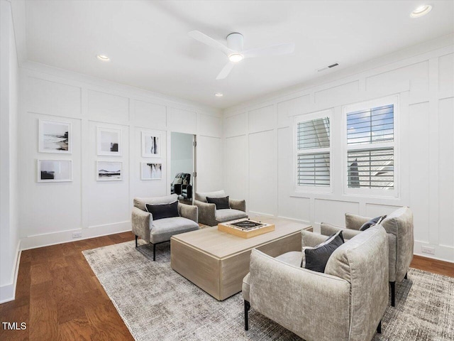 living room with hardwood / wood-style flooring, crown molding, and ceiling fan