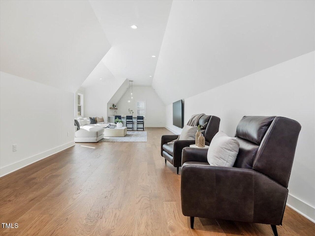 living area with vaulted ceiling and light hardwood / wood-style flooring