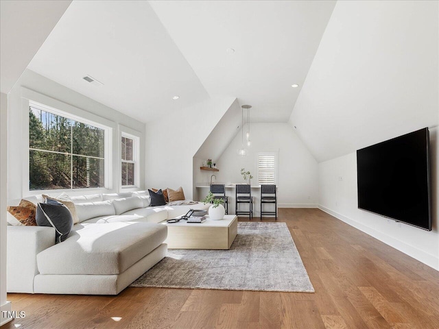 living room featuring lofted ceiling and hardwood / wood-style floors