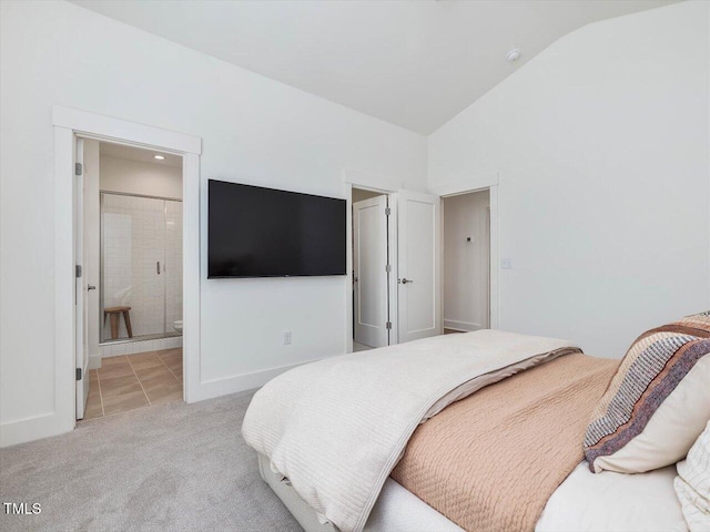 bedroom featuring lofted ceiling, light colored carpet, and ensuite bathroom