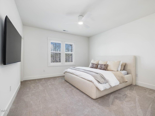 bedroom with ceiling fan and light carpet