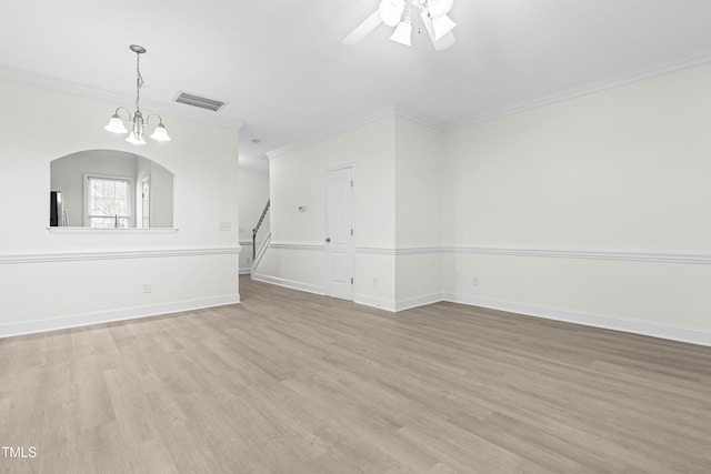 empty room with crown molding, ceiling fan with notable chandelier, and light hardwood / wood-style flooring