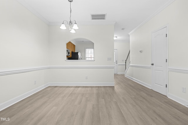 empty room featuring crown molding, light hardwood / wood-style flooring, and a notable chandelier