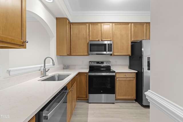 kitchen with sink, light hardwood / wood-style flooring, ornamental molding, stainless steel appliances, and light stone countertops