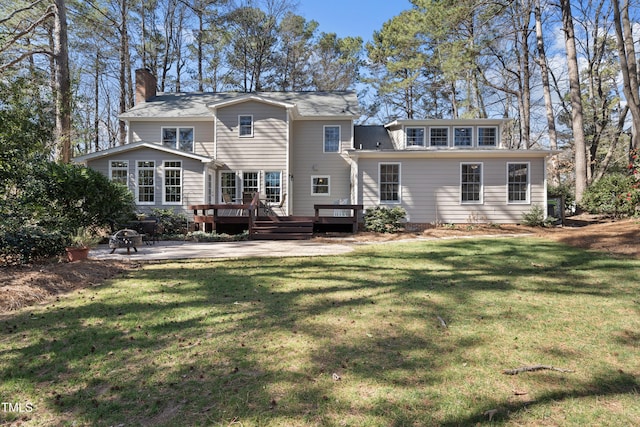 rear view of house featuring a lawn, a patio area, and a wooden deck