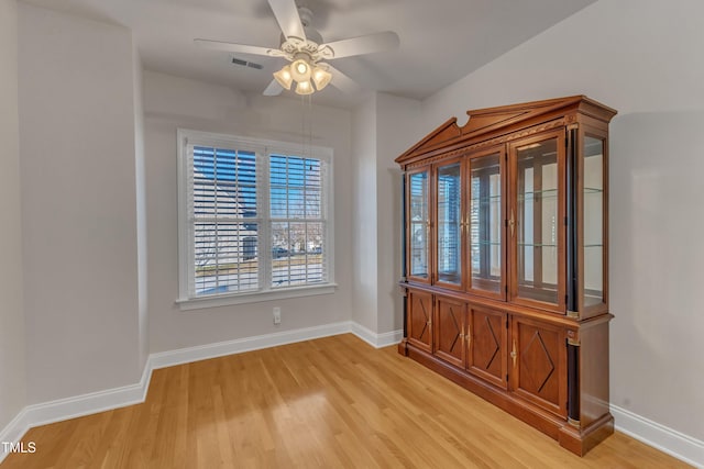 unfurnished dining area with light wood-type flooring, visible vents, ceiling fan, and baseboards