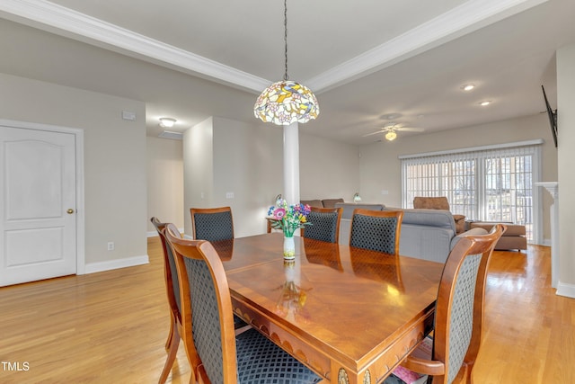 dining area featuring ornamental molding, light wood-style flooring, baseboards, and a ceiling fan