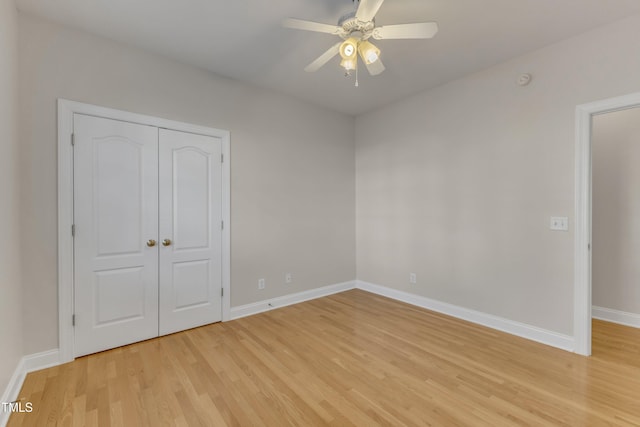 unfurnished bedroom with a ceiling fan, light wood-type flooring, a closet, and baseboards