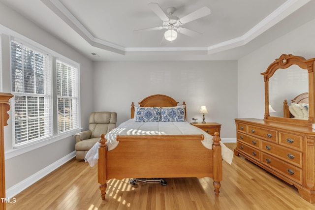 bedroom featuring visible vents, a ceiling fan, baseboards, light wood finished floors, and a raised ceiling