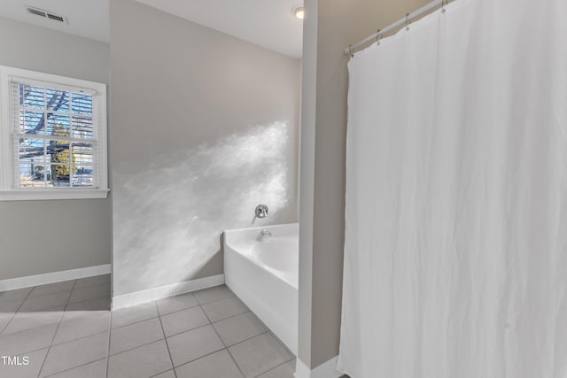 bathroom featuring a garden tub, tile patterned flooring, visible vents, and baseboards