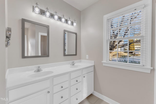 full bathroom featuring baseboards, double vanity, a sink, and tile patterned floors