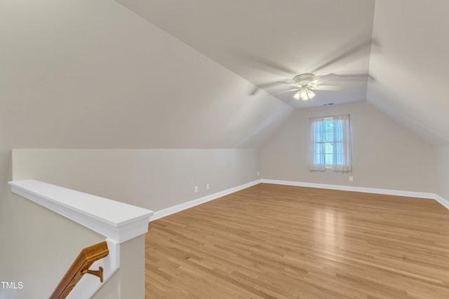 bonus room with light wood finished floors, baseboards, vaulted ceiling, and a ceiling fan