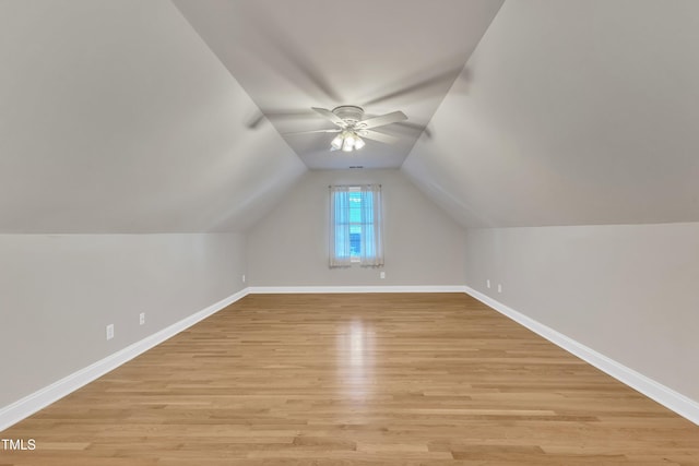 additional living space with lofted ceiling, light wood-style floors, ceiling fan, and baseboards