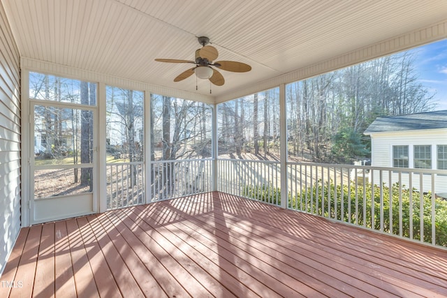 unfurnished sunroom with a ceiling fan and a healthy amount of sunlight