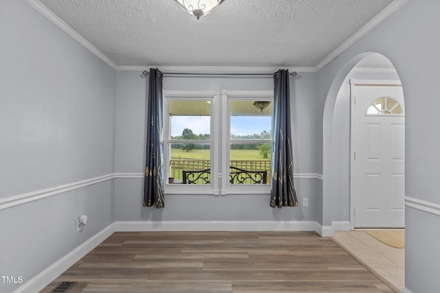 1167 John D Winstead Rd, Roxboro, NC 27574 - unfurnished room featuring arched walkways, healthy amount of natural light, a textured ceiling, wood finished floors, and baseboards