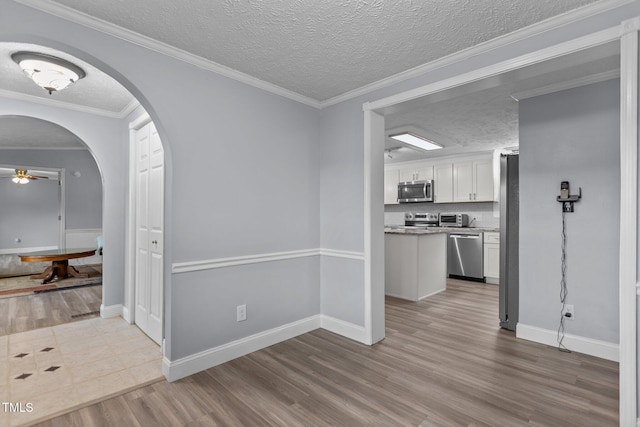 1167 John D Winstead Rd, Roxboro, NC 27574 - unfurnished dining area featuring ceiling fan, a textured ceiling, wood finished floors, arched walkways, and baseboards