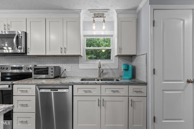 1167 John D Winstead Rd, Roxboro, NC 27574 - kitchen featuring appliances with stainless steel finishes, a sink, backsplash, a textured ceiling, and light stone counters
