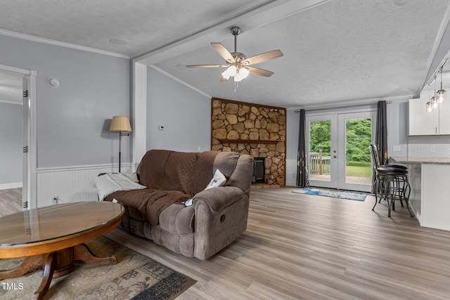 1167 John D Winstead Rd, Roxboro, NC 27574 - living room with a textured ceiling, light wood-type flooring, ceiling fan, crown molding, and a fireplace