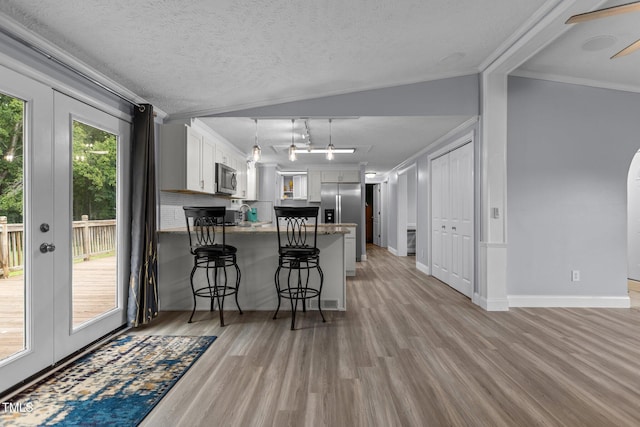 1167 John D Winstead Rd, Roxboro, NC 27574 - kitchen featuring stainless steel appliances, crown molding, a peninsula, light wood-style flooring, and white cabinets