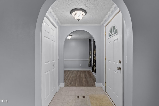 1167 John D Winstead Rd, Roxboro, NC 27574 - corridor featuring ornamental molding, arched walkways, a textured ceiling, tile patterned flooring, and baseboards