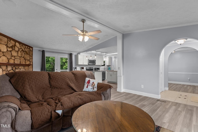 1167 John D Winstead Rd, Roxboro, NC 27574 - living room with a textured ceiling, light wood-type flooring, arched walkways, a ceiling fan, and baseboards
