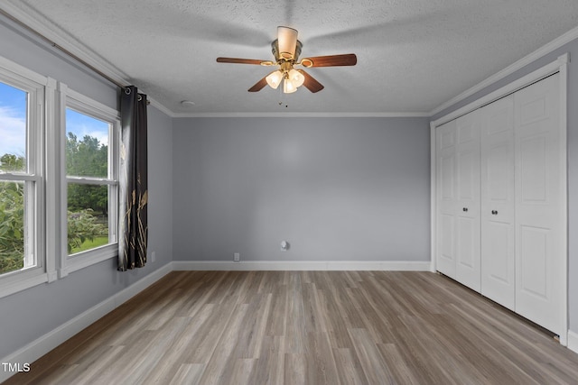 1167 John D Winstead Rd, Roxboro, NC 27574 - unfurnished bedroom with wood finished floors, a textured ceiling, ornamental molding, a closet, and a ceiling fan