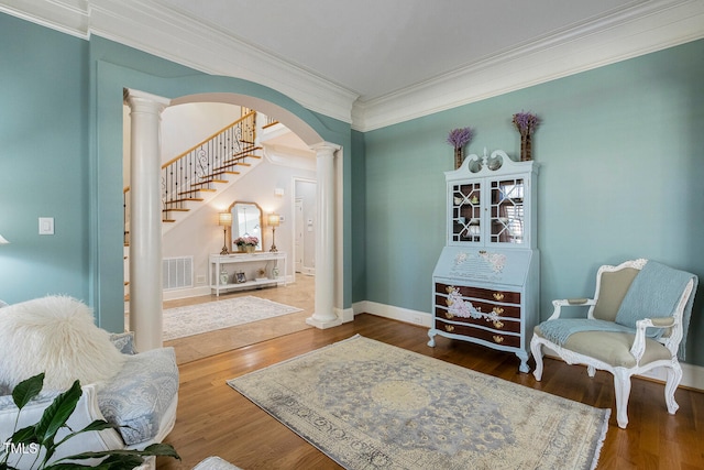 living area with ornamental molding, decorative columns, and hardwood / wood-style floors