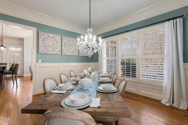 dining room with hardwood / wood-style flooring, ornamental molding, a chandelier, and a healthy amount of sunlight