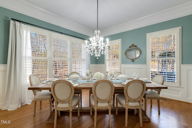 dining room with crown molding, hardwood / wood-style floors, and a notable chandelier