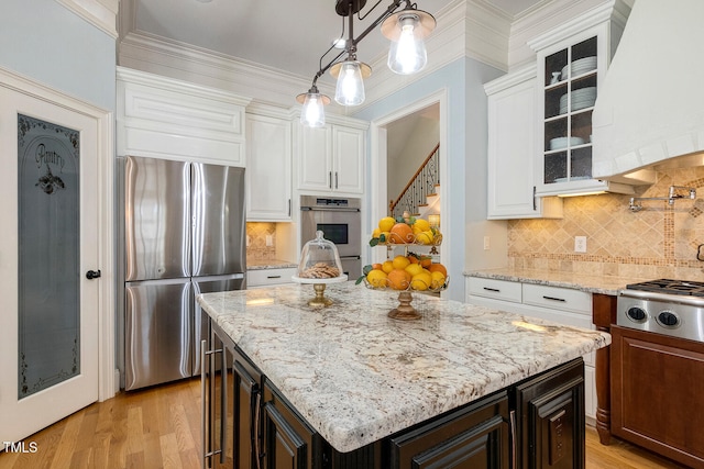 kitchen featuring white cabinetry, a center island, hanging light fixtures, custom range hood, and stainless steel appliances