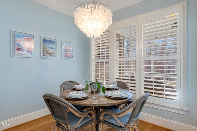 dining room with ornamental molding, light wood-type flooring, and a chandelier