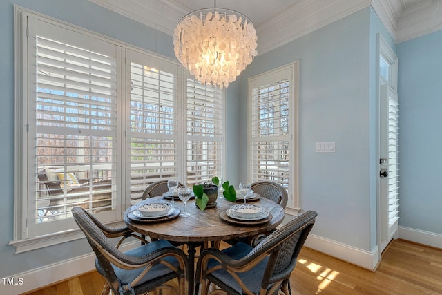 dining area featuring crown molding, a chandelier, and light hardwood / wood-style flooring