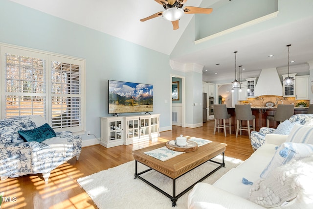 living room featuring ceiling fan, high vaulted ceiling, and light wood-type flooring