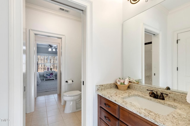 bathroom with tile patterned flooring, vanity, crown molding, and toilet