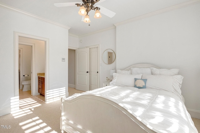 carpeted bedroom with ceiling fan, ornamental molding, and ensuite bathroom