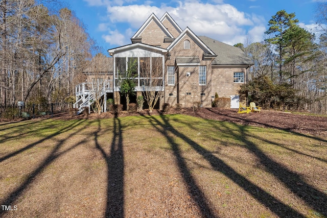 view of front of property featuring a front lawn and a sunroom