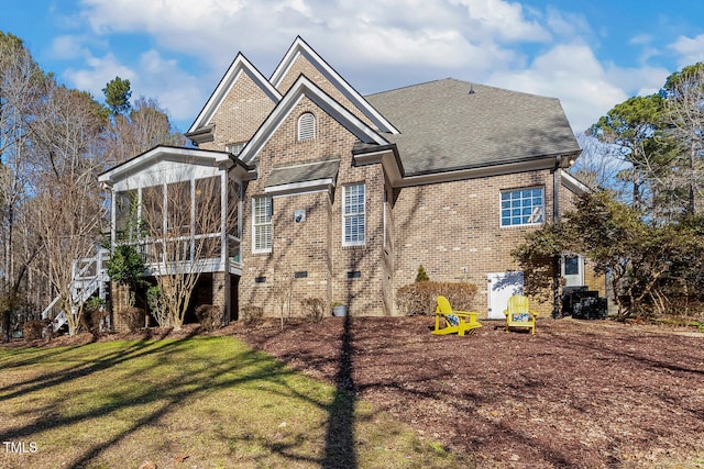 back of house featuring a sunroom and a lawn