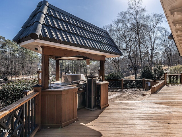 deck with an outdoor kitchen, grilling area, and a bar