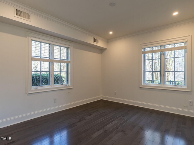 empty room featuring ornamental molding, plenty of natural light, and dark wood-type flooring