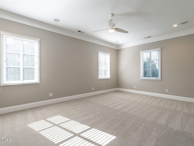 carpeted spare room featuring plenty of natural light, ornamental molding, and ceiling fan