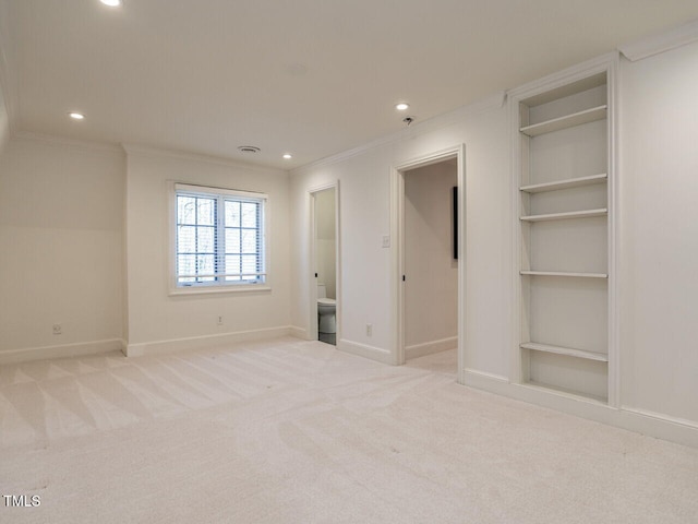 unfurnished bedroom featuring crown molding, connected bathroom, a spacious closet, and light colored carpet