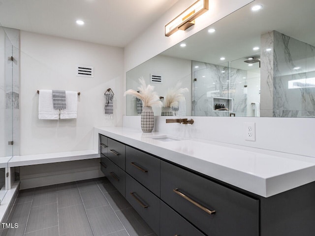 bathroom with vanity and a tile shower