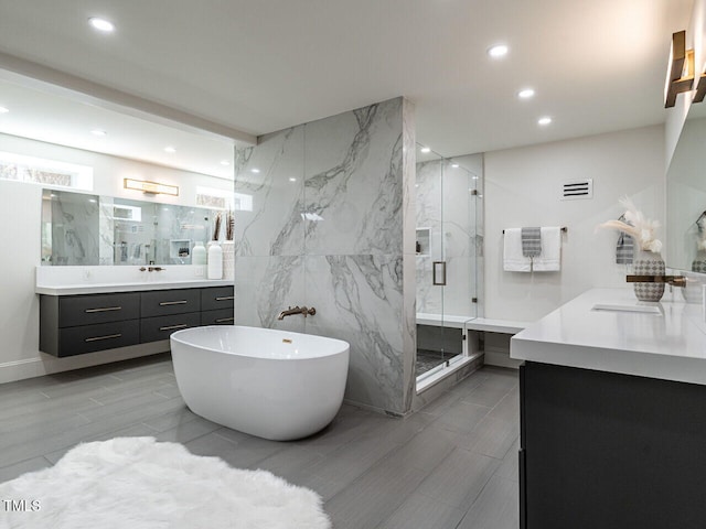 bathroom featuring vanity, separate shower and tub, and tile walls