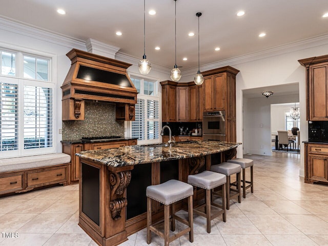 kitchen featuring appliances with stainless steel finishes, sink, dark stone countertops, and a large island