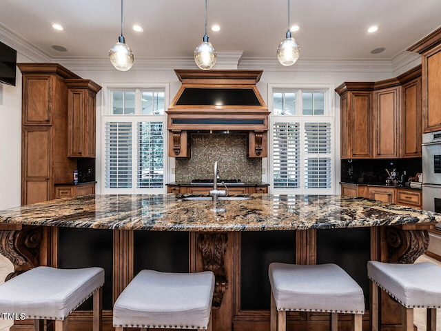 kitchen with hanging light fixtures, a breakfast bar, and dark stone counters