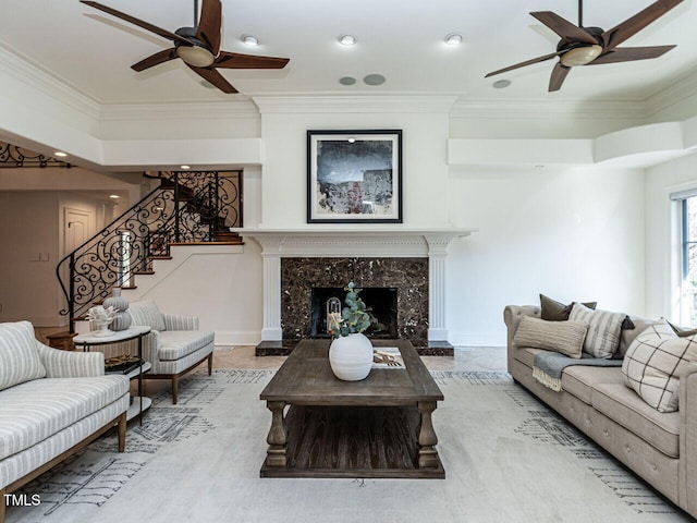 living room with crown molding, a fireplace, and ceiling fan