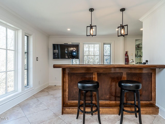 bar with hanging light fixtures, crown molding, a wealth of natural light, and light tile patterned floors